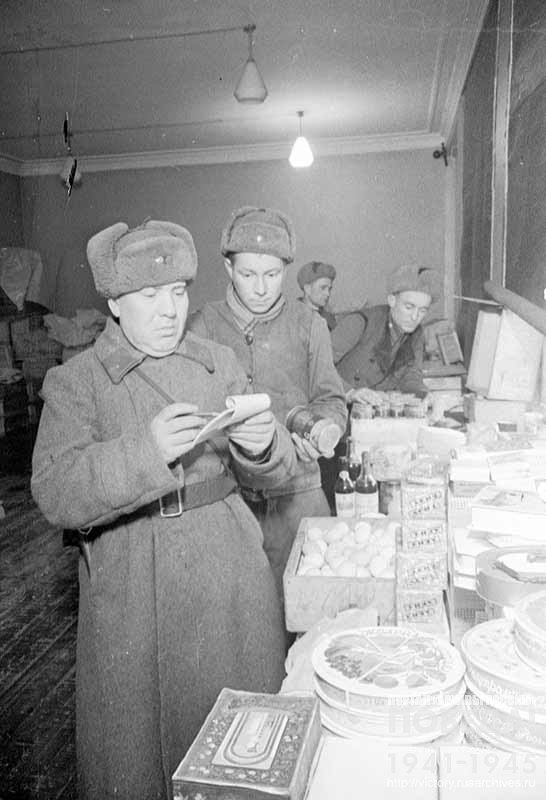 Supervisor of the Parcel Department of one of the forwarding bases in Moscow, E. Efimov and storekeeper of the food warehouse S. Goncharenko check the contents of parcels with gifts prepared to be sent to the front for the 24th Anniversary of the Red Army