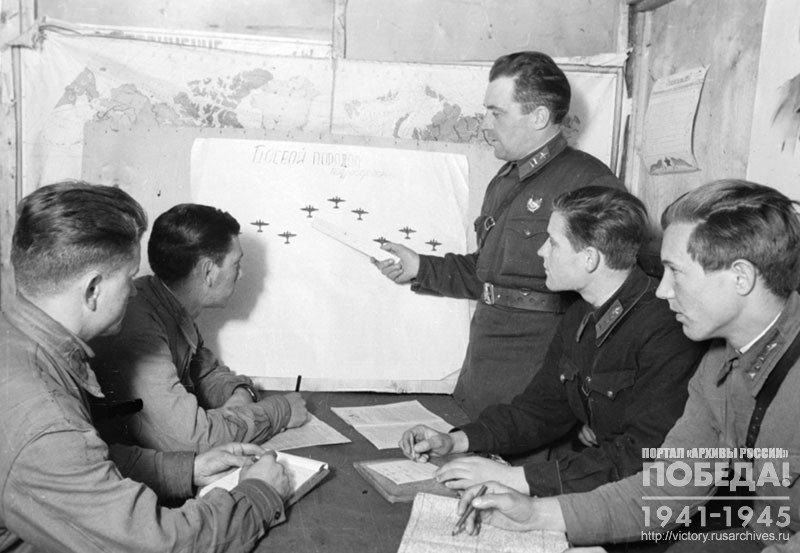 Major P. Osipenko conducts a class with a group of young pilots to study the battle order of air units