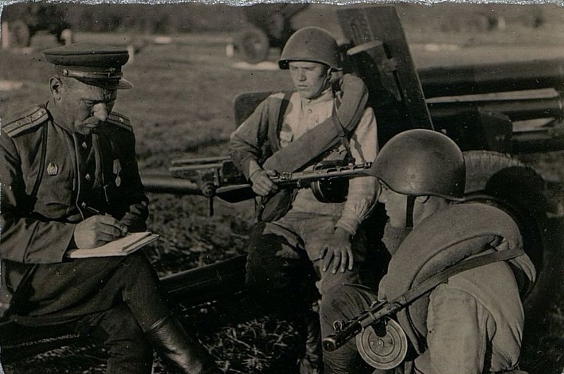 Фотография: Член ДПК (дивизионный партийный комитет) майор товарищ Лабузов, в период между боем, пишет рекомендацию для вступления кандидатом в члены Всесоюзной Коммунистической партии большевиков товарищ Курицыну