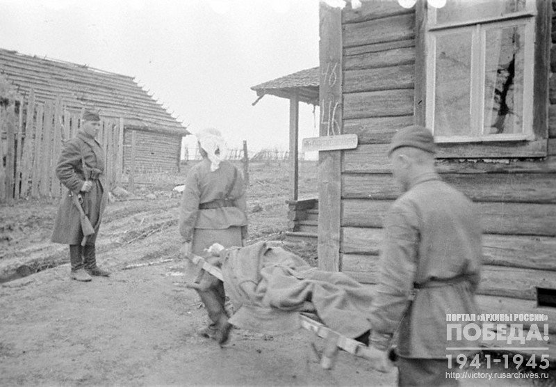 Combat medics carrying a wounded to the operation ward of a field hospital under command of colonel N.N.Oleshev