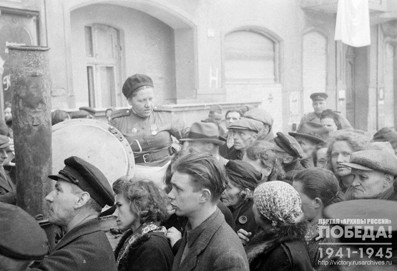 Жители г. Берлина на одной из улиц стоят в очереди за получением супа