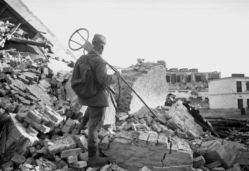 Боец инженерного подразделения Красной Армии с миноискателем на городских развалинах (Берлин)