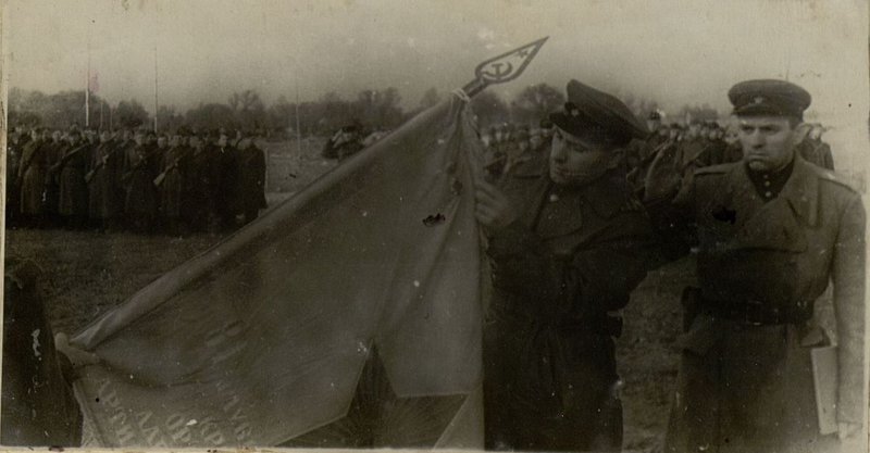 Image: Simultaneously with the presentation of the Red Banner of the Guards Regiment, Colonel Comrade Gubar presented the Order of Alexander Nevsky and attached the Order of the Red Banner and the Order of Alexander Nevsky to the banner.