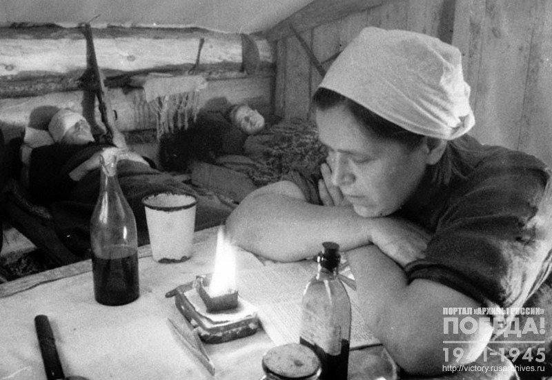 Медицинская сестра дежурит у постелей раненых бойцов в госпитале партизанского отряда имени Котовского
