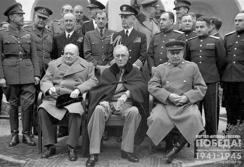 Премьер-министр Великобритании У. Черчилль, Президент США Ф.Д. Рузвельт, глава Советского правительства И.В. Сталин фотографируются для прессы. Среди присутствующих военные советники В. Леги, Д. Эйзенхауер, А.И. Антонов, Н.Г. Кузнецов, С.А. Худяков