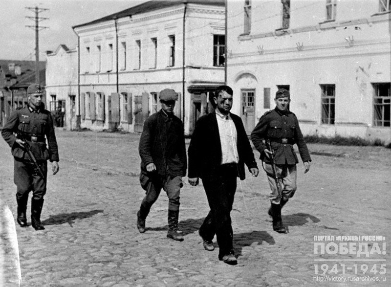 Немецкие солдаты конвоируют двух пленных партизан на одной из улиц Велижа