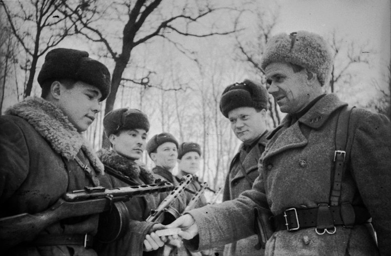 Colonel of the N-unit presents awards to a group of submachine gunners