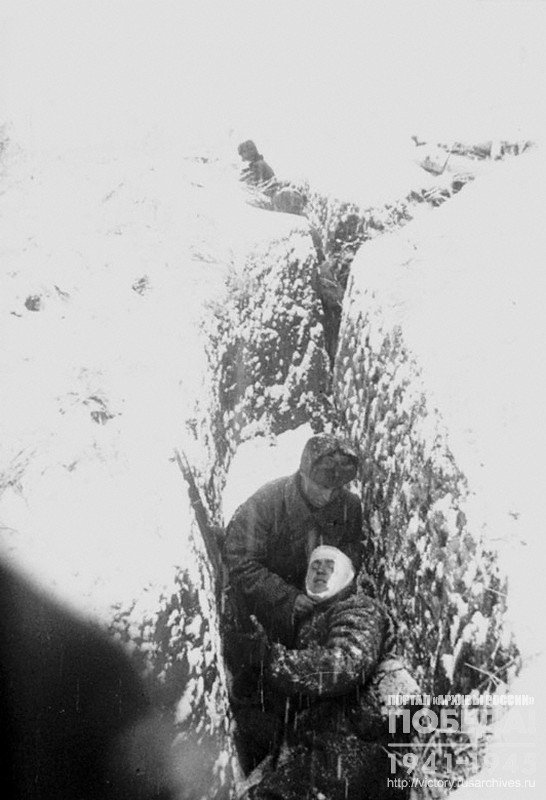 Combat medic A.F.Bogdarin giving medical assistance to wounded sergeant F.L.Lifat