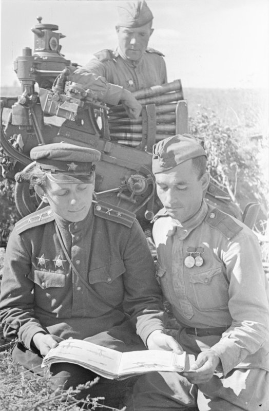 Major A. Grinyak checks the silhouettes of enemy aircraft in the anti-aircraft gun crew of Petty Officer F. Anikin
