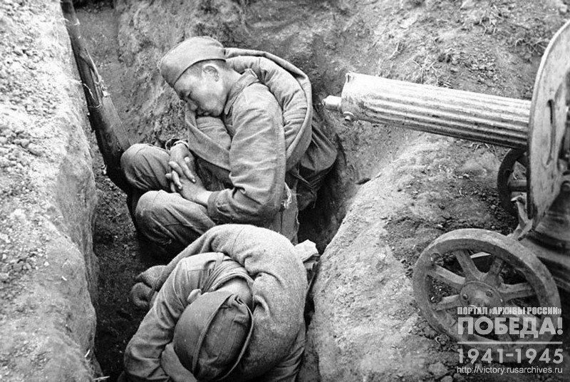 Soldiers sleep at their guns in the trenches after the battle