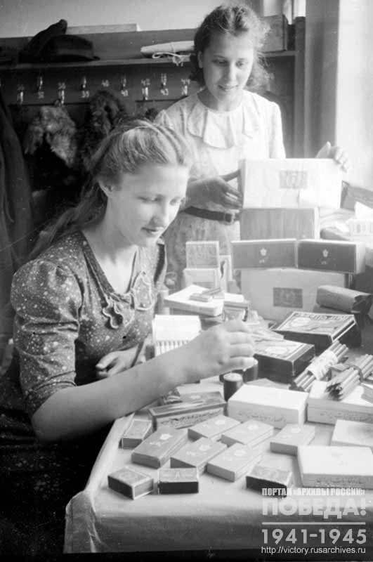 Female employees of one of the Moscow warehouses Z. Morozova and M. Osipova prepare parcels for delivering to the front
