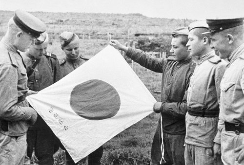 Пограничники заставы им. Валентина Котельникова рассматривают трофейный японский флаг