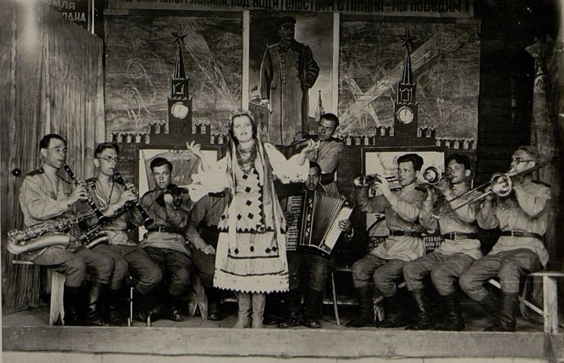 Фотография: Полковой Ансамбль: солисты коллектива (слева направо): Ольга Соломка, Георгий Шипулин, Мария Лагутина. Сопровождает оркестр под руководством краноармееца Б. Галыгина