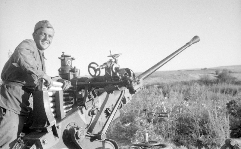Loader of the anti-aircraft gun crew of Specialist Barkov S. Petrov at the gun on the front line