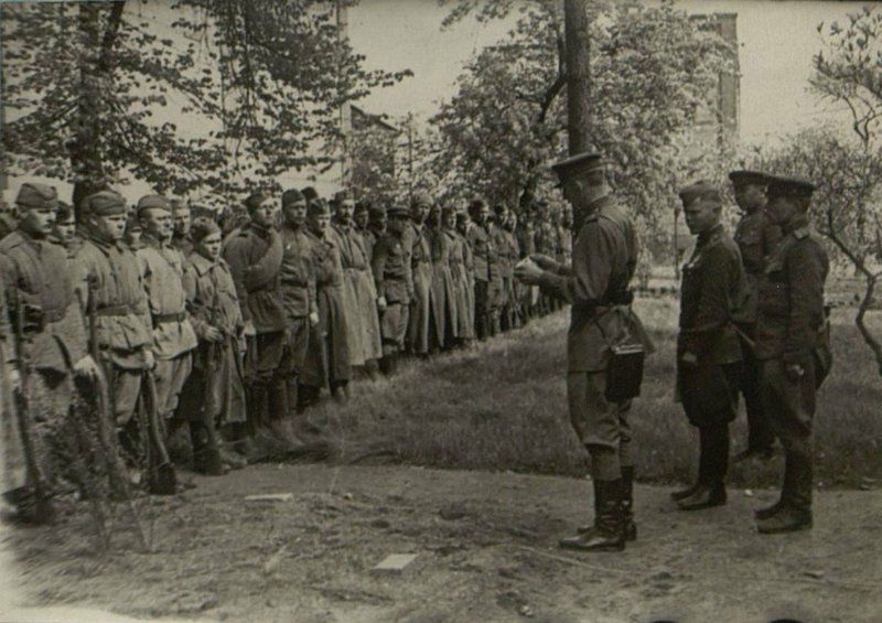 Фотография: Бойцы 121 гвардии стрелковой дивизии встречают первомайский праздник в покоренном гор. Виттенберг. Комбат Москвитин читает первомайский приказ товарища Сталина