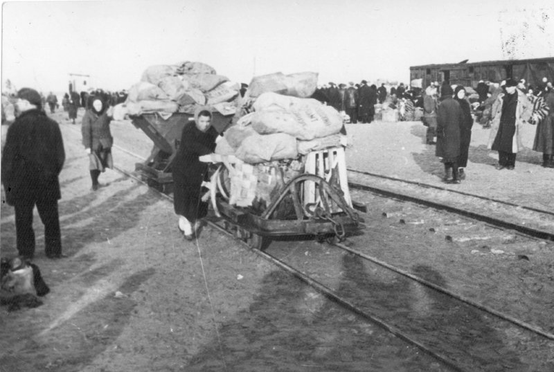 Эвакуированные везут вагонетки с вещами. 1942 г.