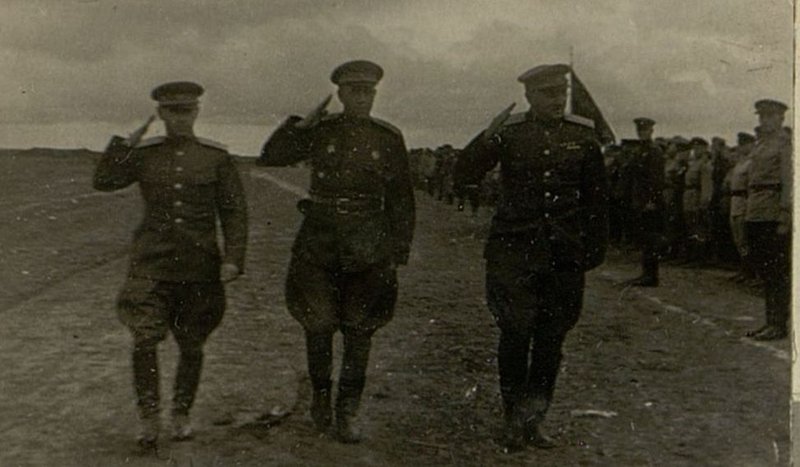 Image: The commander of the North Caucasian Front, Colonel-General Petrov, the commander of the division, Major-General Bushev, and a member of the Military Council of the 18th Army, Major-General Kolonin, pass along the lined columns of guardsmen