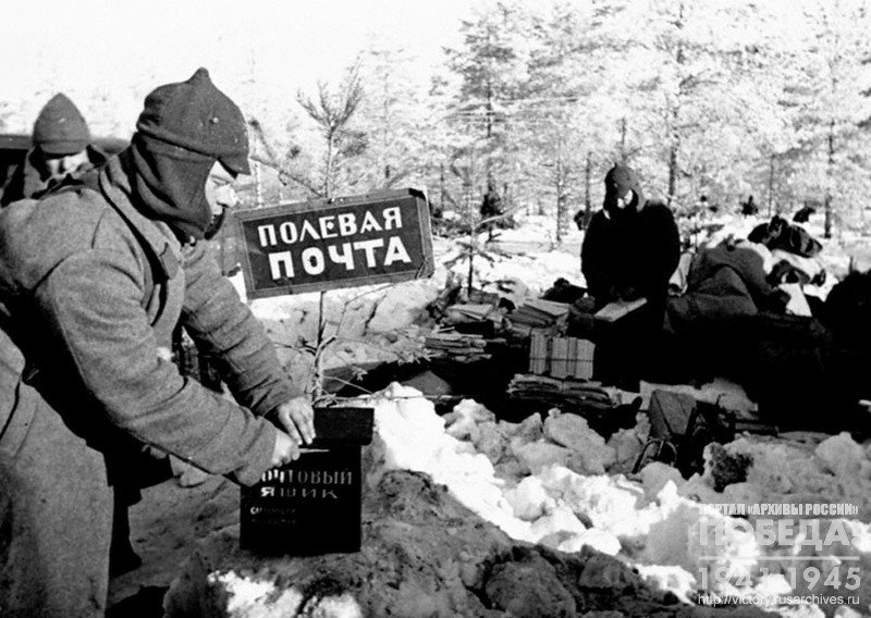Боец Красной Армии опускает письмо в ящик полевой почты