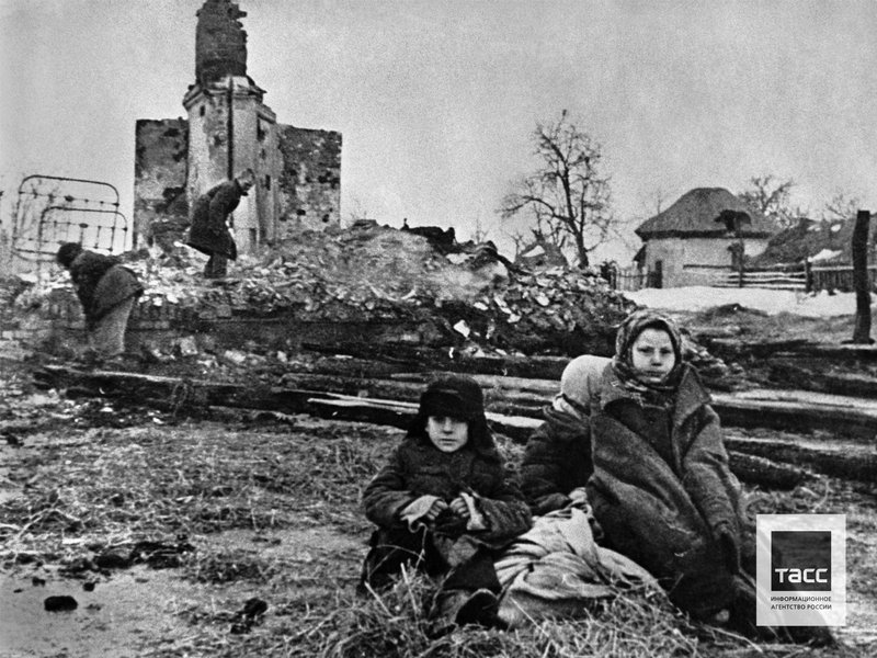Дети Николай, Анна и Таисия Цукановы на месте своего сгоревшего дома в селе Октябрьском, Курская область