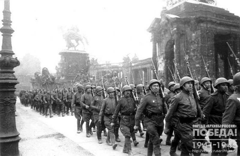 Soviet troops columns passing along  the streets of Berlin