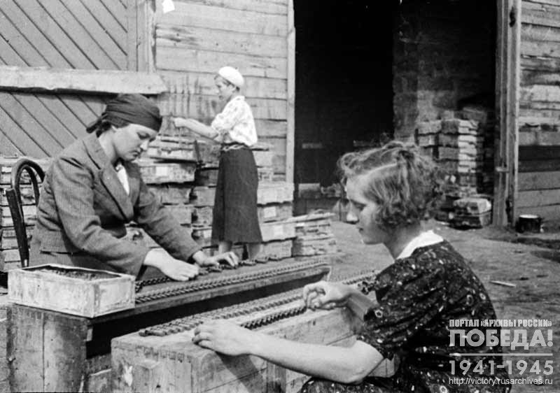 Wives of commanders of the military automobile unit fill machine-gun belts