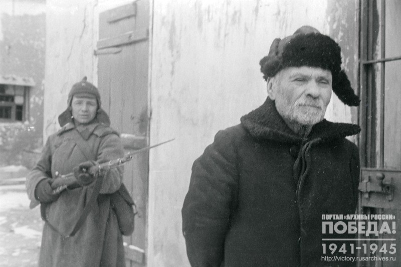 Конвоир ведет на допрос бывшего бургомистра Токарева