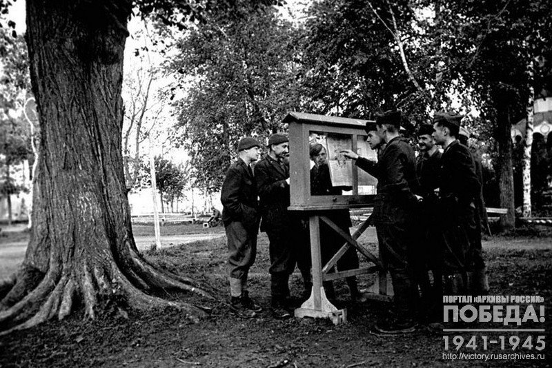 Итальянские и румынские офицеры – военнопленные лагеря № 160 у стенда со свежей газетой