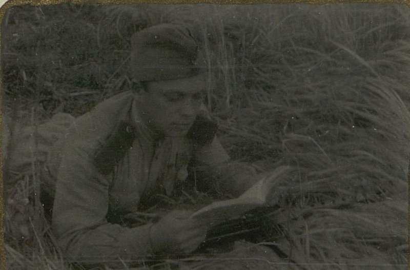 Фотография: Бой затих. Кандидат партии товарищ Ермаков читает книгу тов. Сталина "О Великой отечественной войне Советского Союза"
