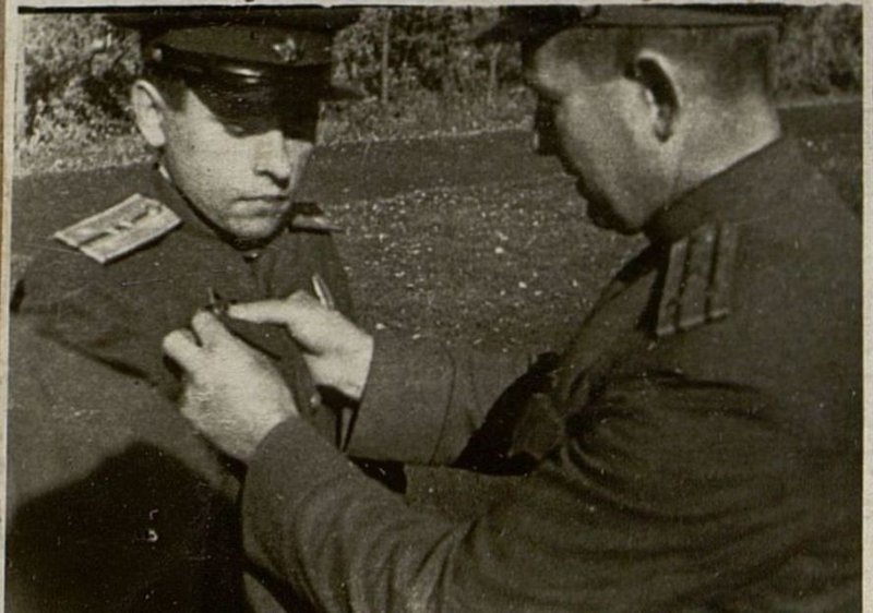 Фотография: Начальник политотдела 12 запасной стрелковой дивизии полковник товарищ Басов укрепляет орден награжденному офицеру товарищ Романенко