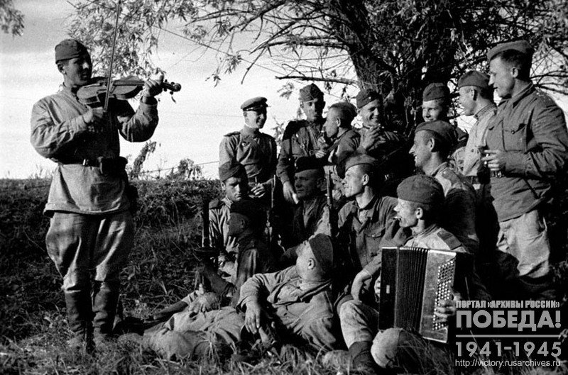 Guardsmen listen to the the violin played by the Red Army guardsman Sergeant V. Aksaisky