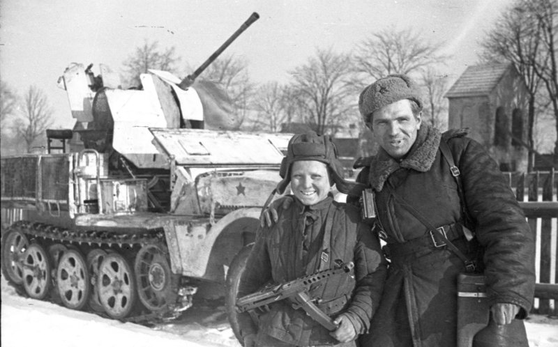 «Подполковник и юный танкист у трофейной зенитной установки Sd.Kfz. 10/5 на Сандомирском плацдарме.»