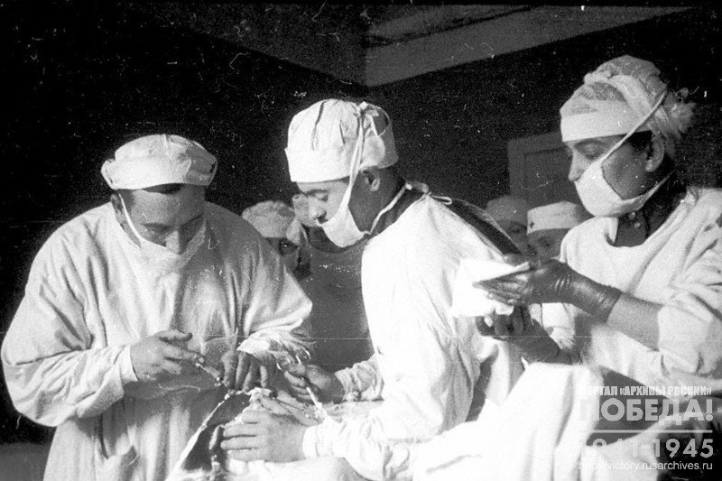 Lead surgeon, major of medical service M.S.Gudkov, and assisting doctor, captain of medical service Biryukov, operating on a wounded soldier in a medical post