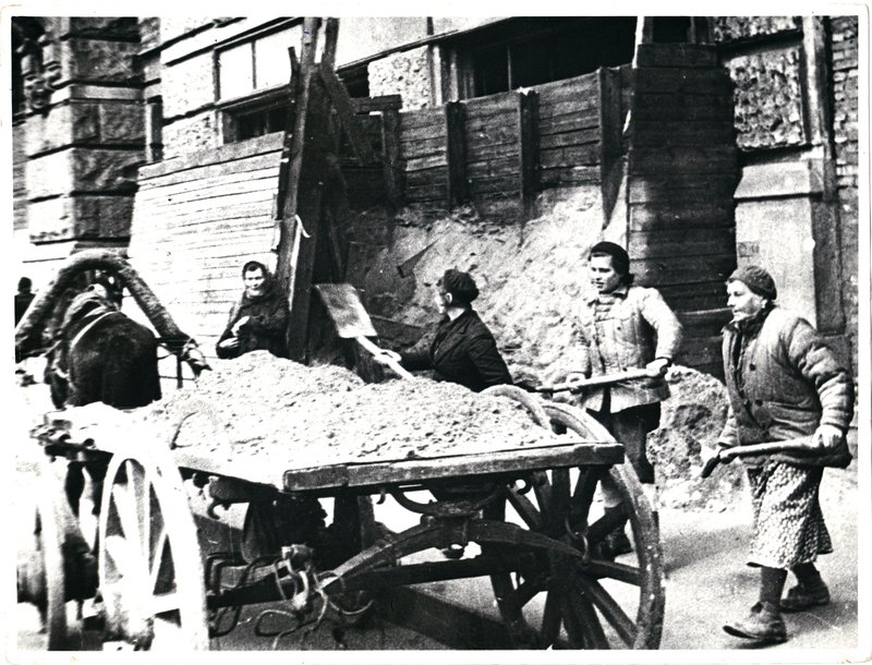 Women dismantle a protective wall at the window of the Eliseevsky store