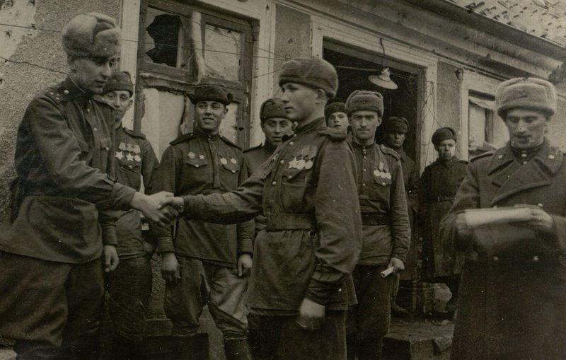 Фотография: Старший инструктор по оргпартработе Политотдела 331 стрелковой дивизии майор Юдицкий после боя зачитывает приказ о награждении отличившихся бойцов и сержантов орденами Славы. Боевые товарищи поздравляют награжденных