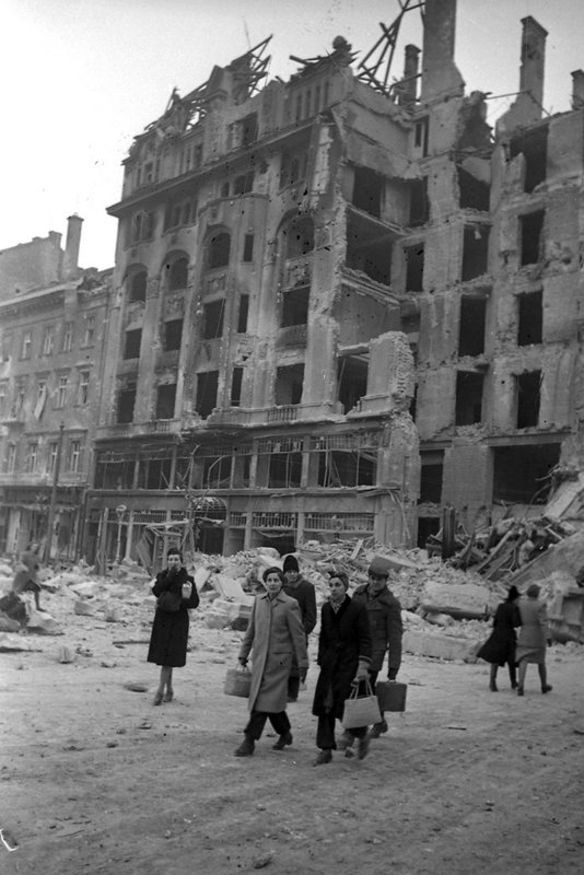 Разрушенные здания на одной из улиц Будапешта. Публика проходит по улице