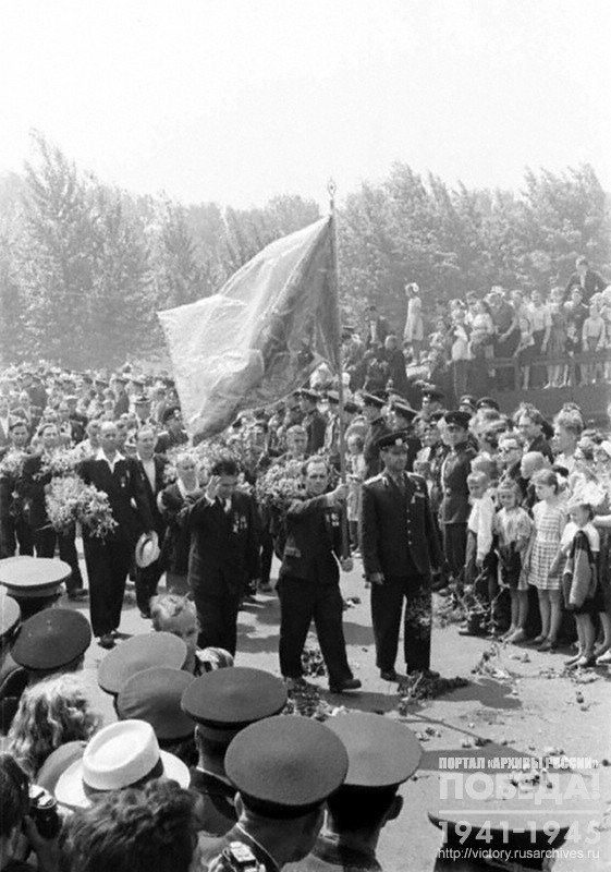 Группа защитников Брестской крепости, прибывших в Брест по случаю 20-летия начала Великой Отечественной войны, выходят из музея обороны с боевым знаменем