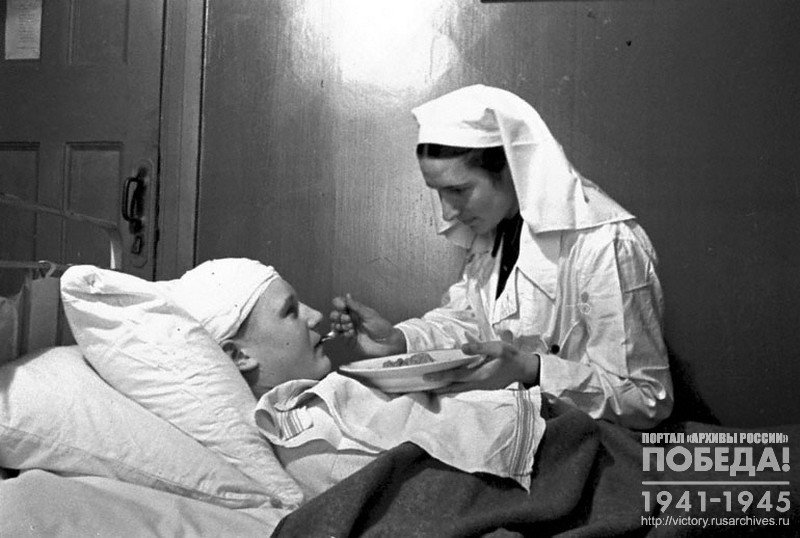Senior nurse A. Kozlova feeding wounded Major V. Nogin in the evacuation and sorting hospital No. 2-386