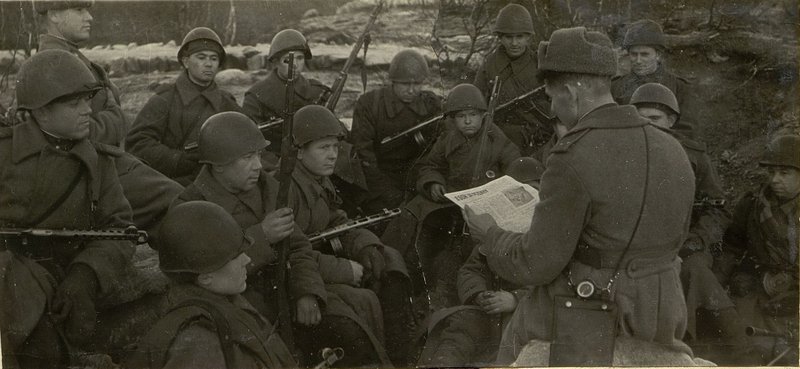 Image: Luostari. Fighters while resting listen to the newspaper reading