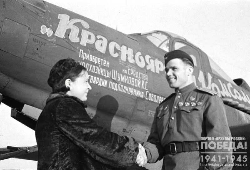 Колхозница сельхозартели «Гудок» К.С. Шумкова беседует с гвардии подполковником Н.Г. Соболевым, получившим самолет «Красноярский комсомолец», построенный на ее личные сбережения