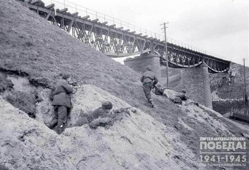 Submachine gunners of the unit of S.A.Popov in combat near a railway bridge in the vicinity of Gdansk (Danzig)