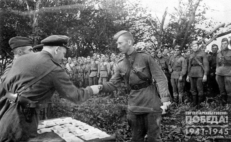 Political commissar (Zampolit) of 129th separate tank brigade, Soviet Union Hero , Colonel A.V. Kottsov presenting Junior lieutenant N.M. Mikhailov with Red Star order, who distinguished himself in Orel’s direction battles