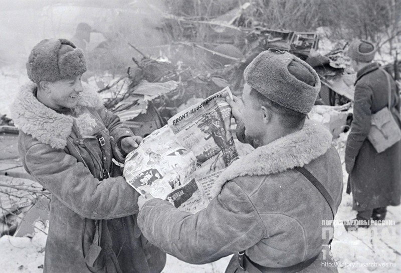 Soldiers examining Soviet leaflets and magazines found at the killed German pilots