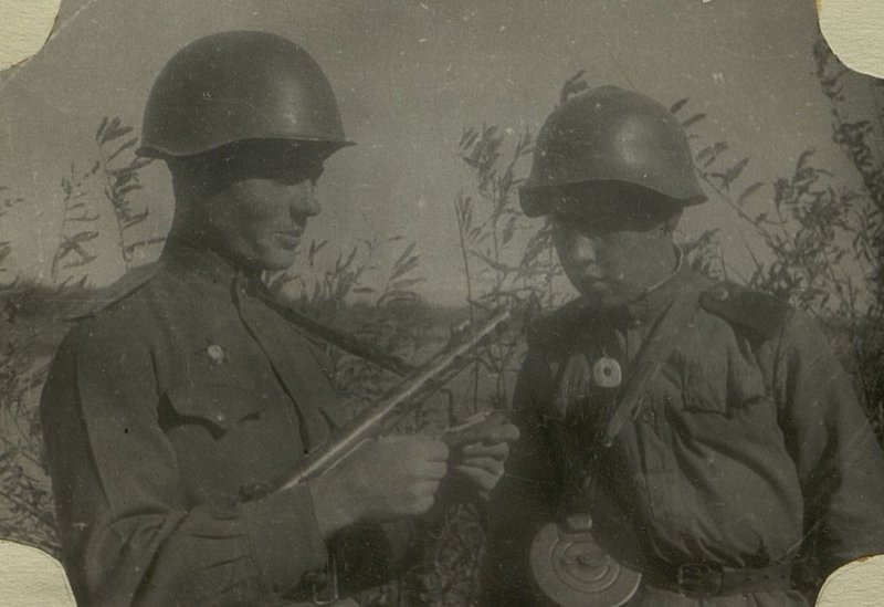 Image: Assistant Chief of the Political Department (P.O.) of the 66th Infantry Division, Senior Lieutenant Luchnikov, talks with the Komsomol instructor about the growth of the Komsomol members