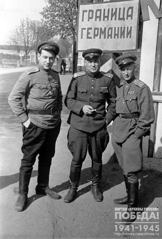 Фотокорреспондент Темин В.А., кинооператор Кармен Р. с советским офицером на КПП одного из участков границы с Германией