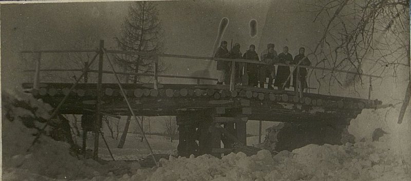 Фотография: Построенный мост в Дружево с использованием немецкой металлической опоры. На мосту стоит в середине прапорщик II роты Старший прапорщик Кузьменко. По краям гражданки местного населения, которые производили очистку дороги от снега