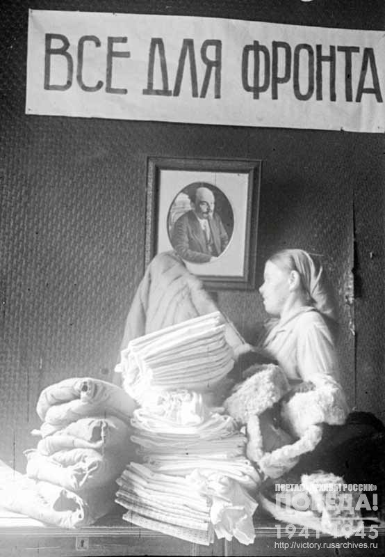 Storekeeper of the City Commission for collecting warm clothes for soldiers of the Red Army T. Dogadina sorts things accepted from residents of Chkalov