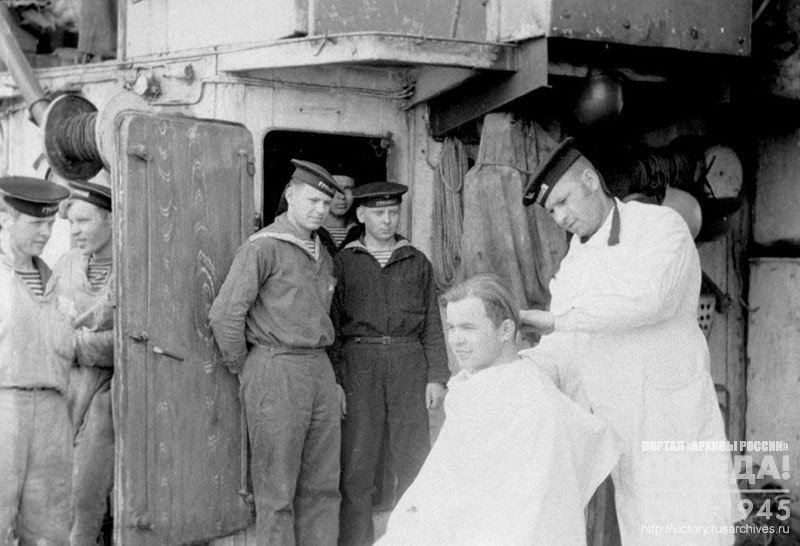 Ship's barber is making haircuts to sailors after a military campaign