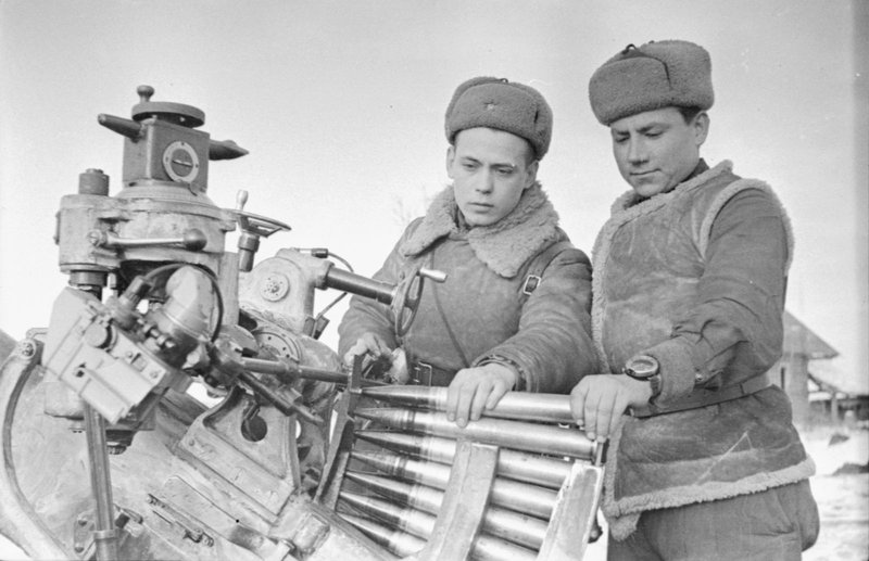 Commander of the anti-aircraft battery Senior Lieutenant V. Chekmenev and his Deputy Lieutenant Aligberov inspecting military equipment