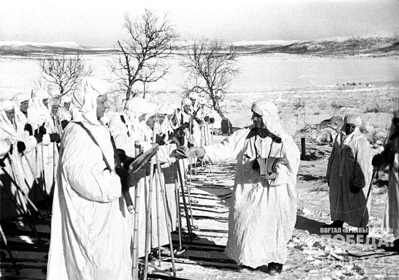 Начальник разведки гвардейской части старший лейтенант В.Д. Прадедов раздает бойцам листовки для разбрасывания их в тылу противника