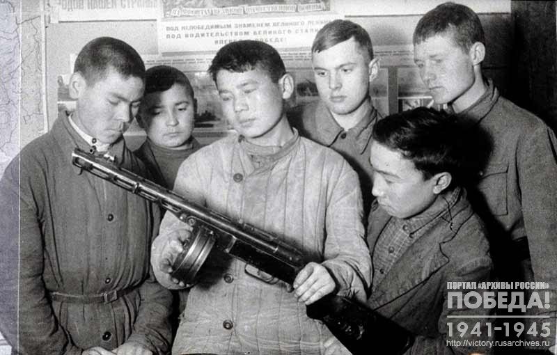 Young people of the Pervomaiskiy District of Frunze studying a submachine gun in Vevobuch classes of 4th stage